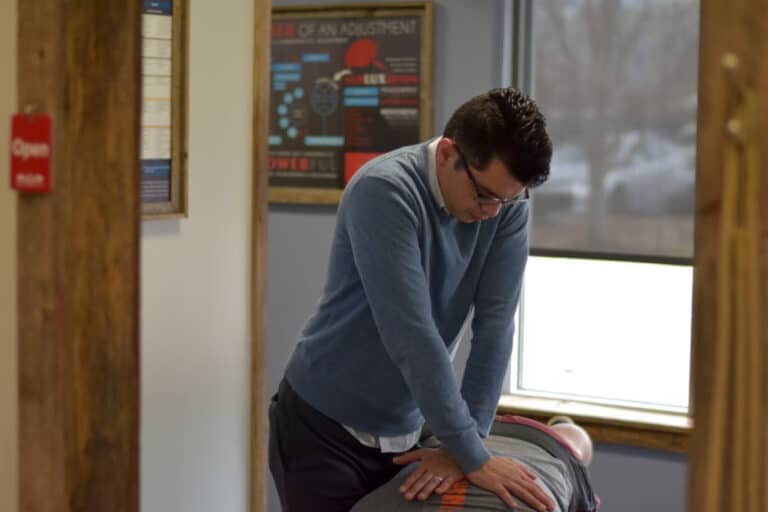 Dr. Oscar noriega DC helping patient with back pain