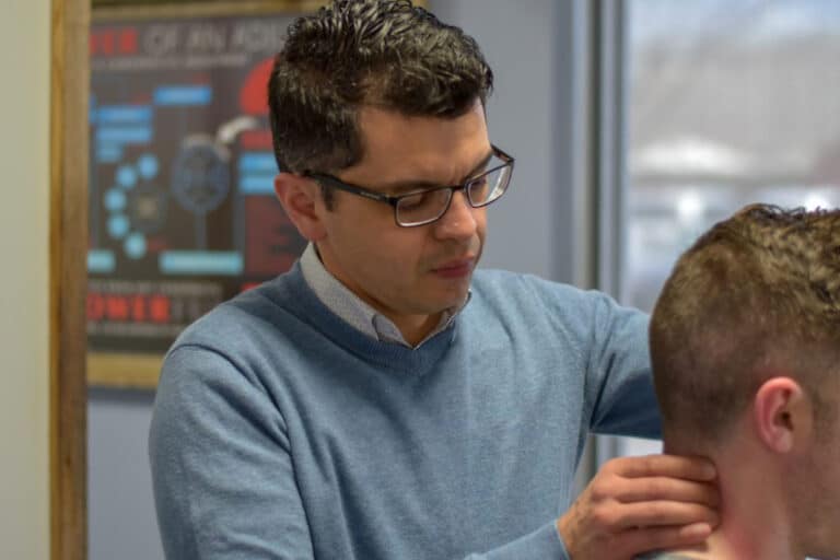 Dr. Oscar Noriega helping patient with neck pain